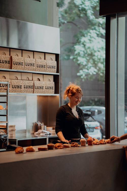 Barista serving pastries at Lune Bakery Melbourne - hospitality ORM Melbourne coffee culture