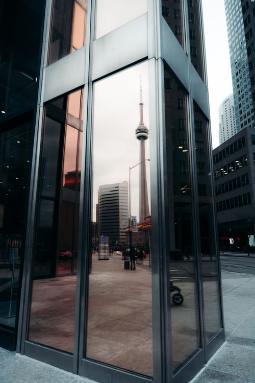 CN Tower reflected in glass building Toronto sports - sports reputation management BMO Field